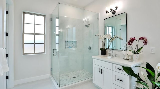 full bath with a shower stall, vanity, and healthy amount of natural light