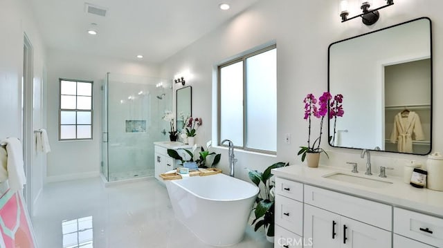 bathroom featuring a shower stall, vanity, a freestanding tub, and recessed lighting