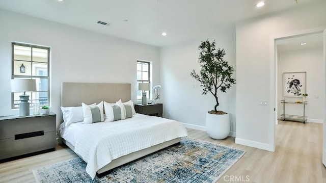 bedroom with light wood-style floors, recessed lighting, and baseboards