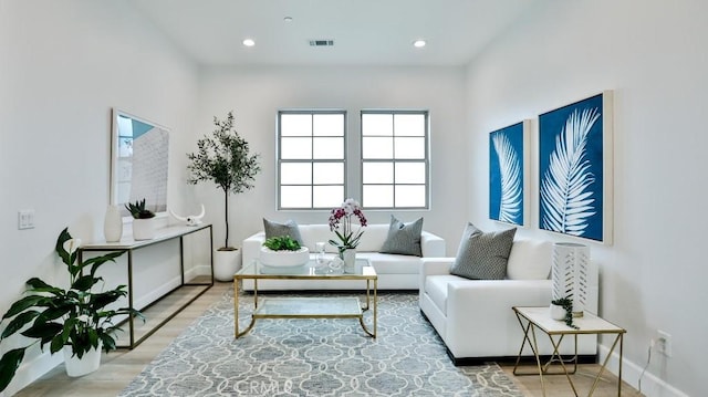 living area with baseboards, recessed lighting, and light wood-style flooring