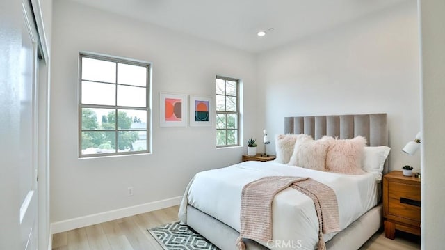 bedroom with light wood-style flooring, baseboards, and recessed lighting