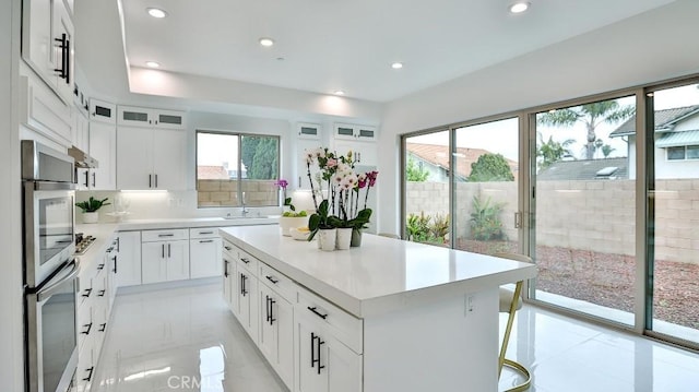 kitchen featuring plenty of natural light, stainless steel double oven, recessed lighting, and light countertops