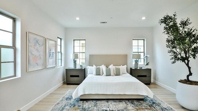 bedroom with light wood-style flooring, baseboards, and recessed lighting