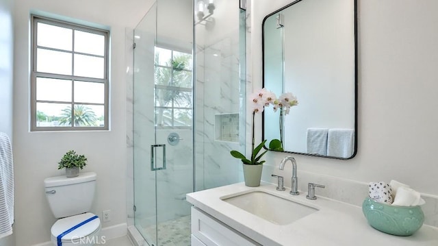 full bathroom with a marble finish shower, toilet, vanity, and baseboards
