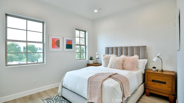 bedroom with light wood-style floors, baseboards, and recessed lighting