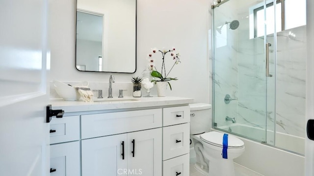 full bath with toilet, vanity, and combined bath / shower with glass door