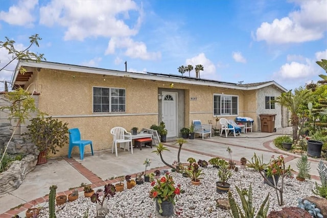 9502 Westminster Ave, Garden Grove, CA 92844 - view of front of home featuring stucco siding, roof mounted solar panels, and a patio area