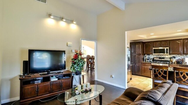 86069 Village Unit 69, Costa Mesa, CA 92626 - living area featuring high vaulted ceiling, beam ceiling, and baseboards