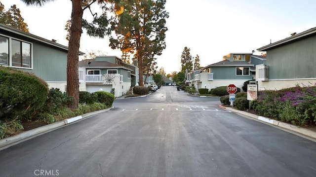 86069 Village Unit 69, Costa Mesa, CA 92626 - view of asphalt road featuring a residential view, traffic signs, and curbs