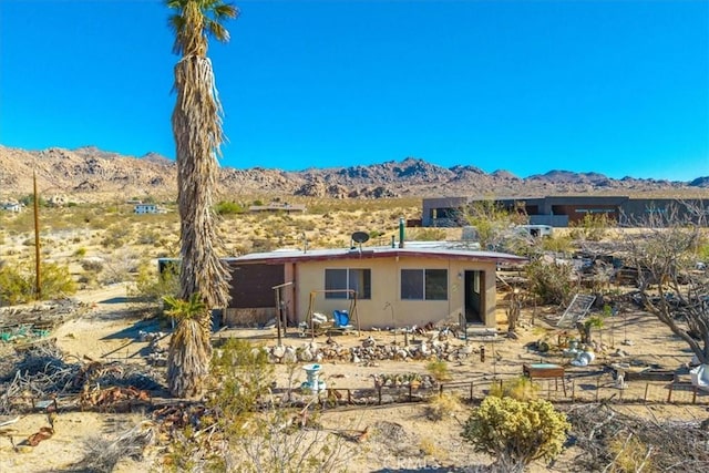 7037 Calapooya Way, Joshua Tree, CA 92252 - back of house featuring a mountain view, stucco siding, and view of desert landscape