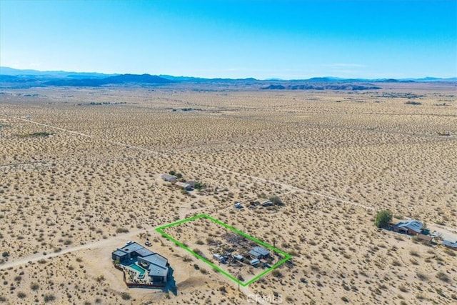 7037 Calapooya Way, Joshua Tree, CA 92252 - aerial view of sparsely populated area featuring a desert landscape, property boundaries highlighted, and a mountainous background