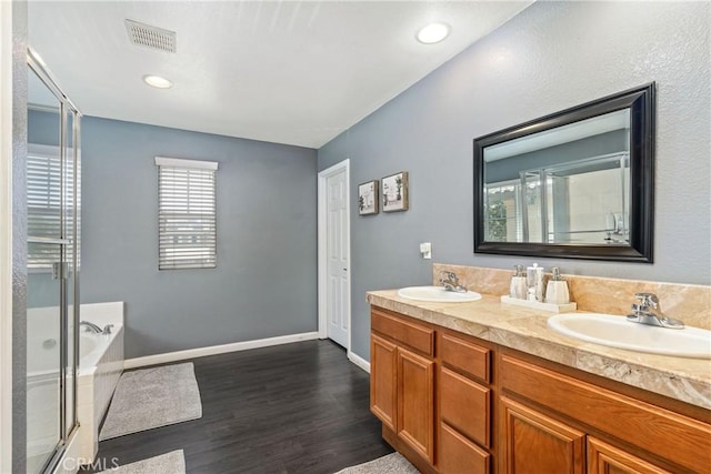 893 Whimbrel Way, Perris, CA 92571 - full bath with wood finished floors, a bath, double vanity, an enclosed shower, and baseboards