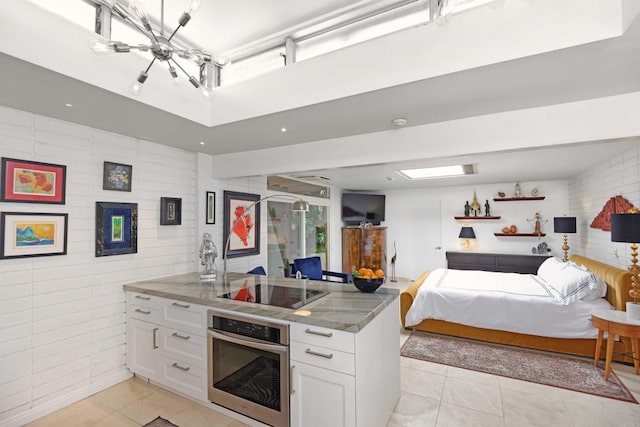 567 Gage Ln, San Diego, CA 92106 - bedroom featuring light tile patterned flooring, a chandelier, and tile walls