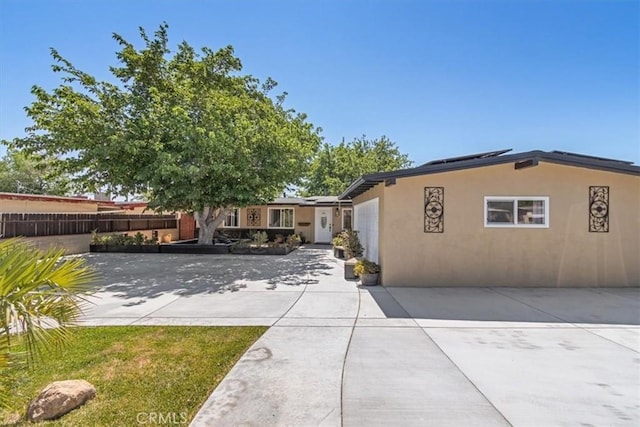 38868 Yucca Tree St, Palmdale, CA 93551 - view of front facade featuring stucco siding and roof mounted solar panels