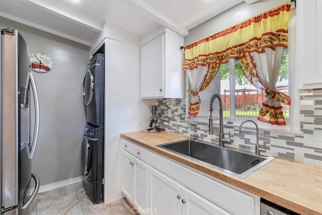 38868 Yucca Tree St, Palmdale, CA 93551 - kitchen with stainless steel refrigerator with ice dispenser, a sink, stacked washing machine and dryer, butcher block countertops, and tasteful backsplash