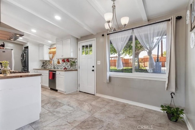 38868 Yucca Tree St, Palmdale, CA 93551 - kitchen with estacked washer and dryer, beamed ceiling, white cabinetry, tasteful backsplash, and a chandelier