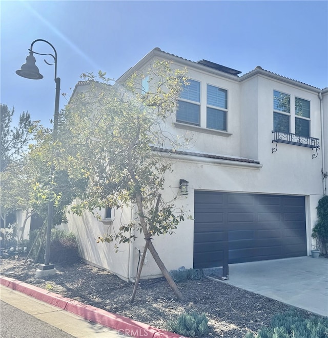 299 E Arrow Hwy Unit 4, Glendora, CA 91740 - view of front of home with an attached garage, stucco siding, and concrete driveway