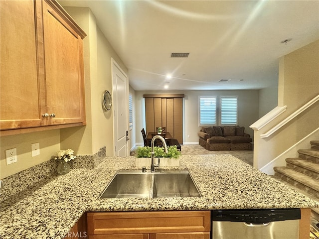 299 E Arrow Hwy Unit 4, Glendora, CA 91740 - kitchen with stainless steel dishwasher, a sink, open floor plan, brown cabinetry, and light stone countertops