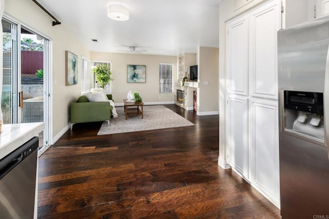 3362 Edgeview, San Marcos, CA 92078 - living room with dark wood-type flooring, a ceiling fan, a glass covered fireplace, and baseboards