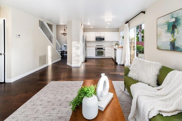 3362 Edgeview, San Marcos, CA 92078 - living area featuring dark wood finished floors, stairway, a chandelier, and baseboards