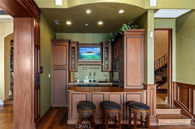 367 Monterey Pines Dr, Arcadia, CA 91006 - indoor wet bar featuring dark wood-style flooring, stairway, recessed lighting, arched walkways, and a wainscoted wall