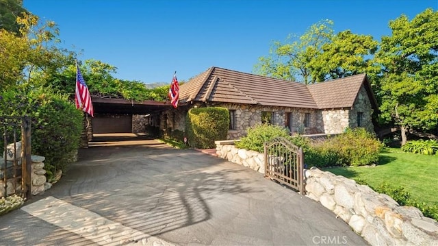 2304 Rosedale Curv, Upland, CA 91784 - view of side of property featuring stone siding, asphalt driveway, and a yard