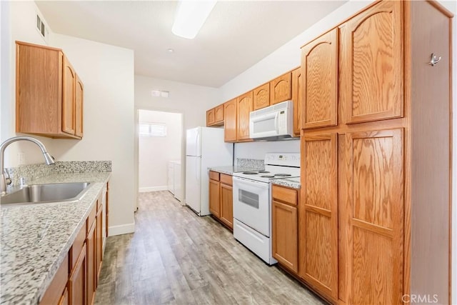 41410 Juniper St Unit 2622, Murrieta, CA 92562 - kitchen featuring white appliances, a sink, light wood-type flooring, washer / dryer, and baseboards
