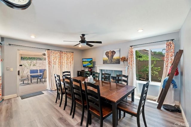 3079 Mojave Ct, Highland, CA 92346 - dining room with light wood-style floors, a ceiling fan, baseboards, a tile fireplace, and recessed lighting
