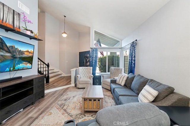 3079 Mojave Ct, Highland, CA 92346 - living area featuring wood finished floors, stairway, high vaulted ceiling, and baseboards