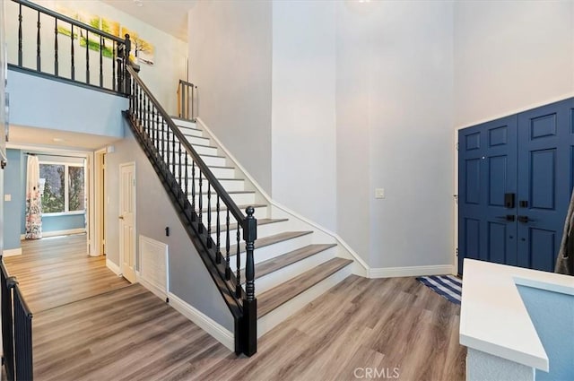 3079 Mojave Ct, Highland, CA 92346 - entryway with a towering ceiling, wood finished floors, baseboards, and stairway