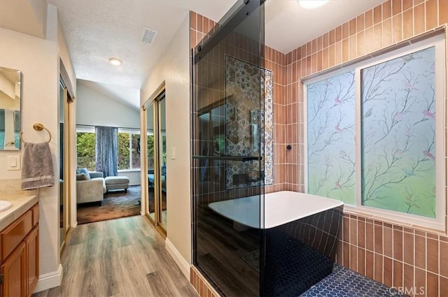 3079 Mojave Ct, Highland, CA 92346 - ensuite bathroom featuring vanity, wood finished floors, lofted ceiling, a stall shower, and a soaking tub