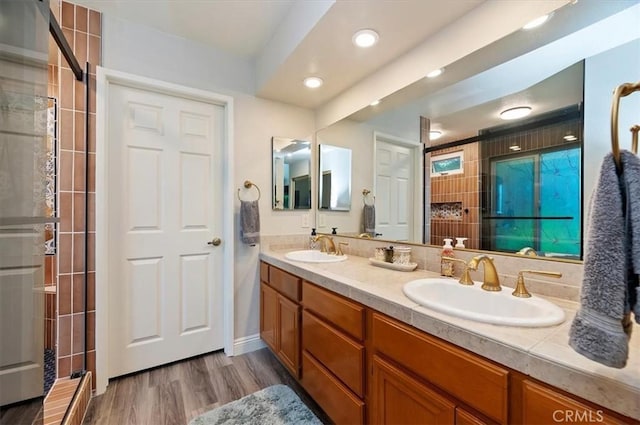 3079 Mojave Ct, Highland, CA 92346 - full bathroom featuring double vanity, a tile shower, wood finished floors, and recessed lighting