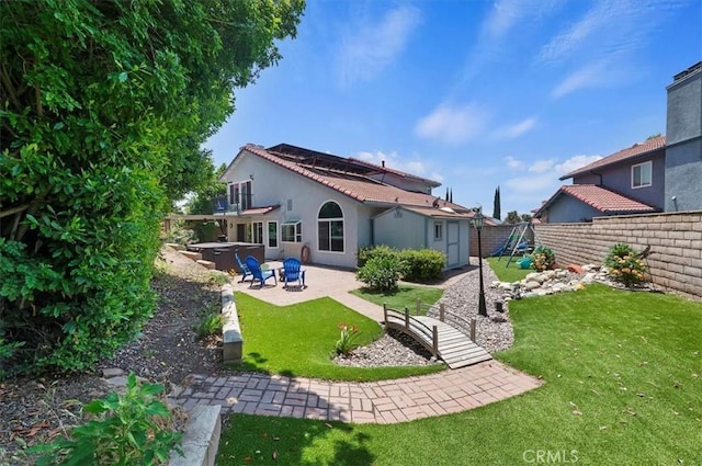 3079 Mojave Ct, Highland, CA 92346 - rear view of property featuring a hot tub, a patio area, and stucco siding