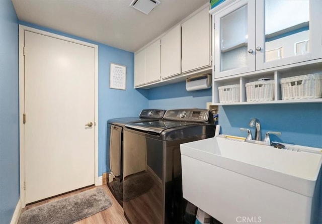 3079 Mojave Ct, Highland, CA 92346 - laundry room featuring separate washer and dryer, wood finished floors, cabinet space, and baseboards