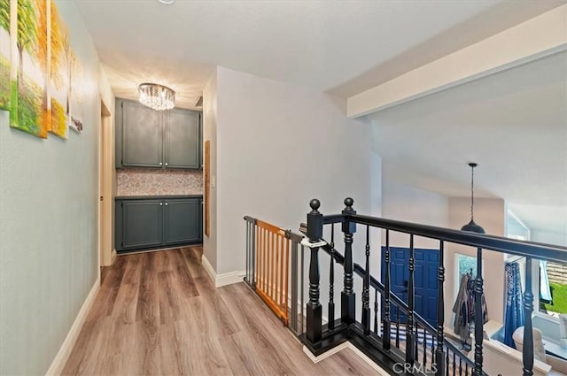 3079 Mojave Ct, Highland, CA 92346 - hallway with an upstairs landing, a chandelier, wood finished floors, and baseboards