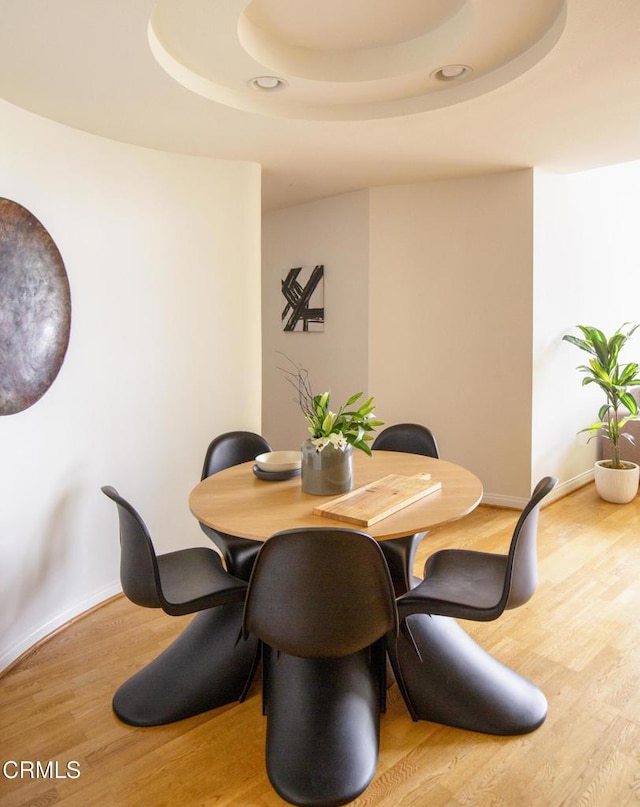 12603 Moorpark St Unit 303, Studio City, CA 91604 - dining space featuring a raised ceiling, wood finished floors, and baseboards