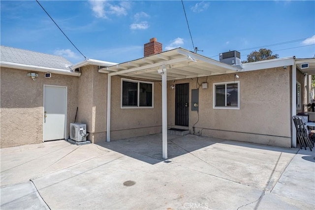 15439 Studebaker Rd, Norwalk, CA 90650 - rear view of house featuring stucco siding, a chimney, a cooling unit, and a patio area