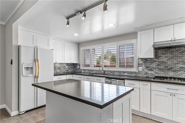 15439 Studebaker Rd, Norwalk, CA 90650 - kitchen with stainless steel appliances, a sink, under cabinet range hood, dark countertops, and light wood-type flooring