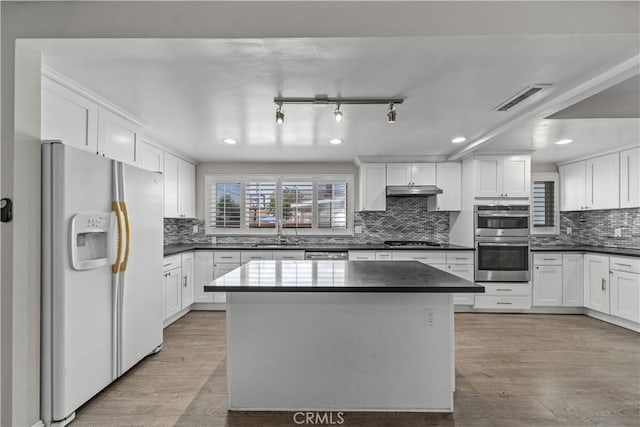 15439 Studebaker Rd, Norwalk, CA 90650 - kitchen with appliances with stainless steel finishes, a sink, dark countertops, decorative backsplash, and white cabinets
