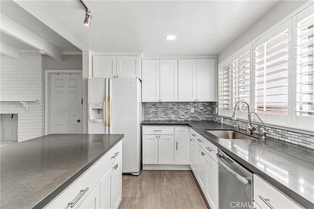 15439 Studebaker Rd, Norwalk, CA 90650 - kitchen with white fridge with ice dispenser, stainless steel dishwasher, a sink, white cabinetry, and tasteful backsplash