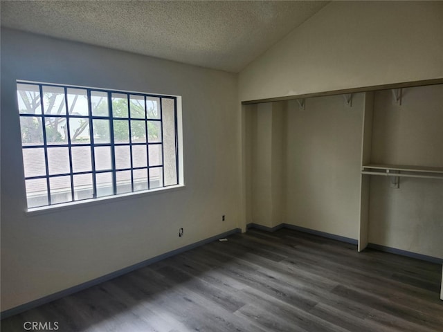 2220 E Chapman Ave Unit 51, Fullerton, CA 92831 - unfurnished bedroom featuring dark wood finished floors, a closet, a textured ceiling, baseboards, and vaulted ceiling
