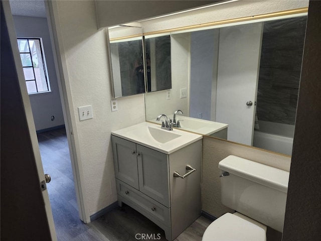 2220 E Chapman Ave Unit 51, Fullerton, CA 92831 - bathroom with wood finished floors, vanity, toilet, baseboards, and a textured wall