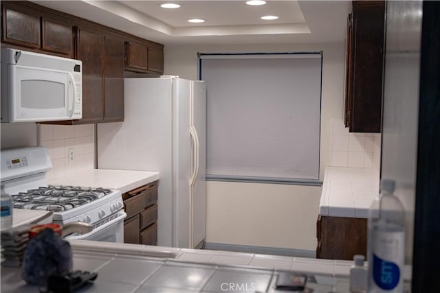 2220 E Chapman Ave Unit 51, Fullerton, CA 92831 - kitchen with white appliances, a tray ceiling, dark brown cabinets, backsplash, and recessed lighting