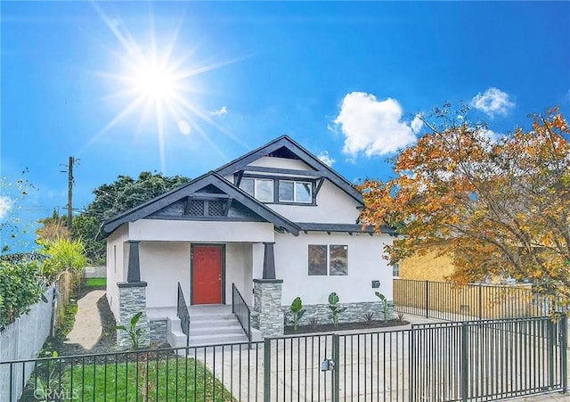 160 W 48th St, Los Angeles, CA 90037 - view of front of house featuring stucco siding, a fenced front yard, and stone siding