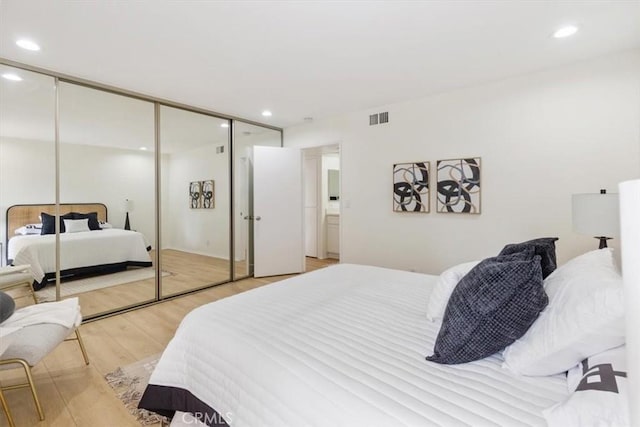 bedroom with light wood finished floors, a closet, and recessed lighting