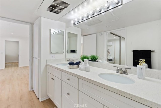 bathroom with double vanity and wood finished floors