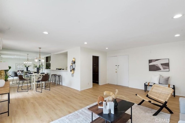 living area featuring wood finished floors, recessed lighting, and a chandelier