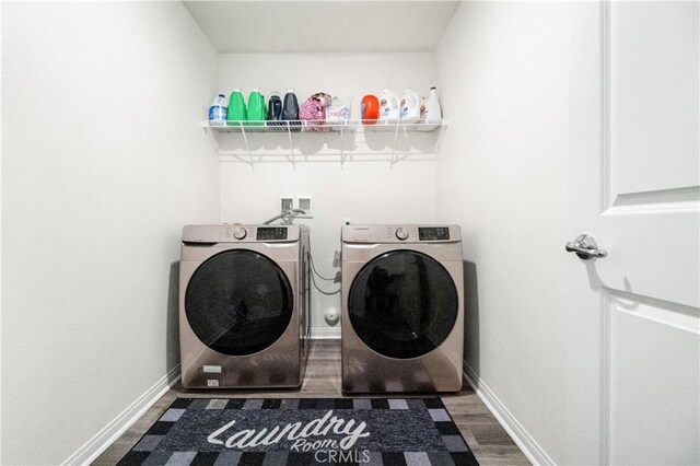 2044 E Lingard St, Lancaster, CA 93535 - laundry area with washer and dryer, wood finished floors, and baseboards