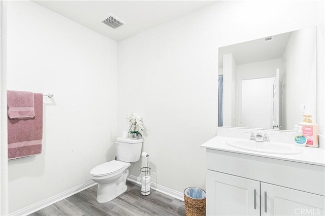 2044 E Lingard St, Lancaster, CA 93535 - bathroom with wood finished floors, baseboards, vanity, and toilet