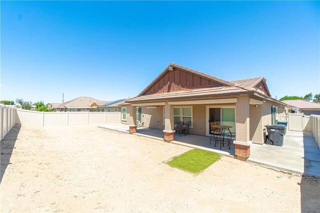 2044 E Lingard St, Lancaster, CA 93535 - rear view of property featuring a patio, a fenced backyard, stucco siding, and board and batten siding